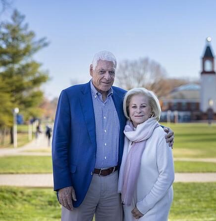 Bill and Barbara Weldon posing for a picture in front of the Arnold Bernhard Library.